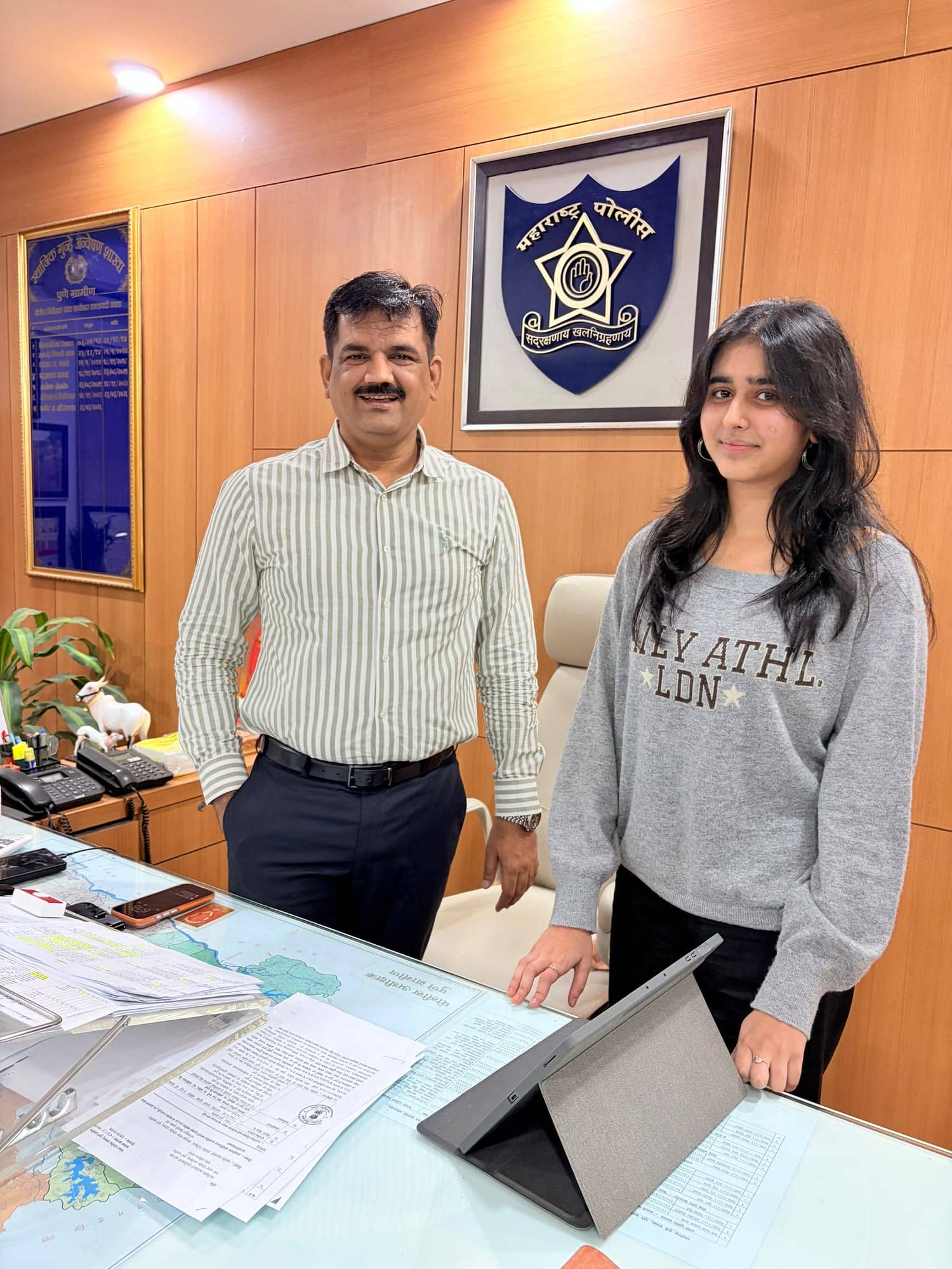 Reeti Maniar of ByteByByte with a police officer at the branch, the police emblem on the wall behind them.