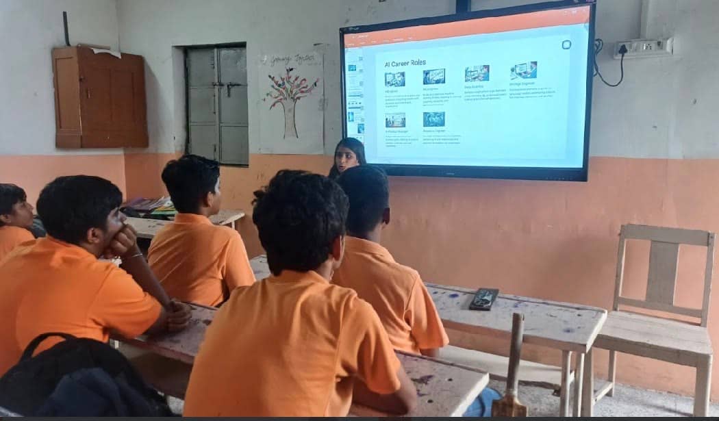 A classroom of students facing a screen, shot from the back.