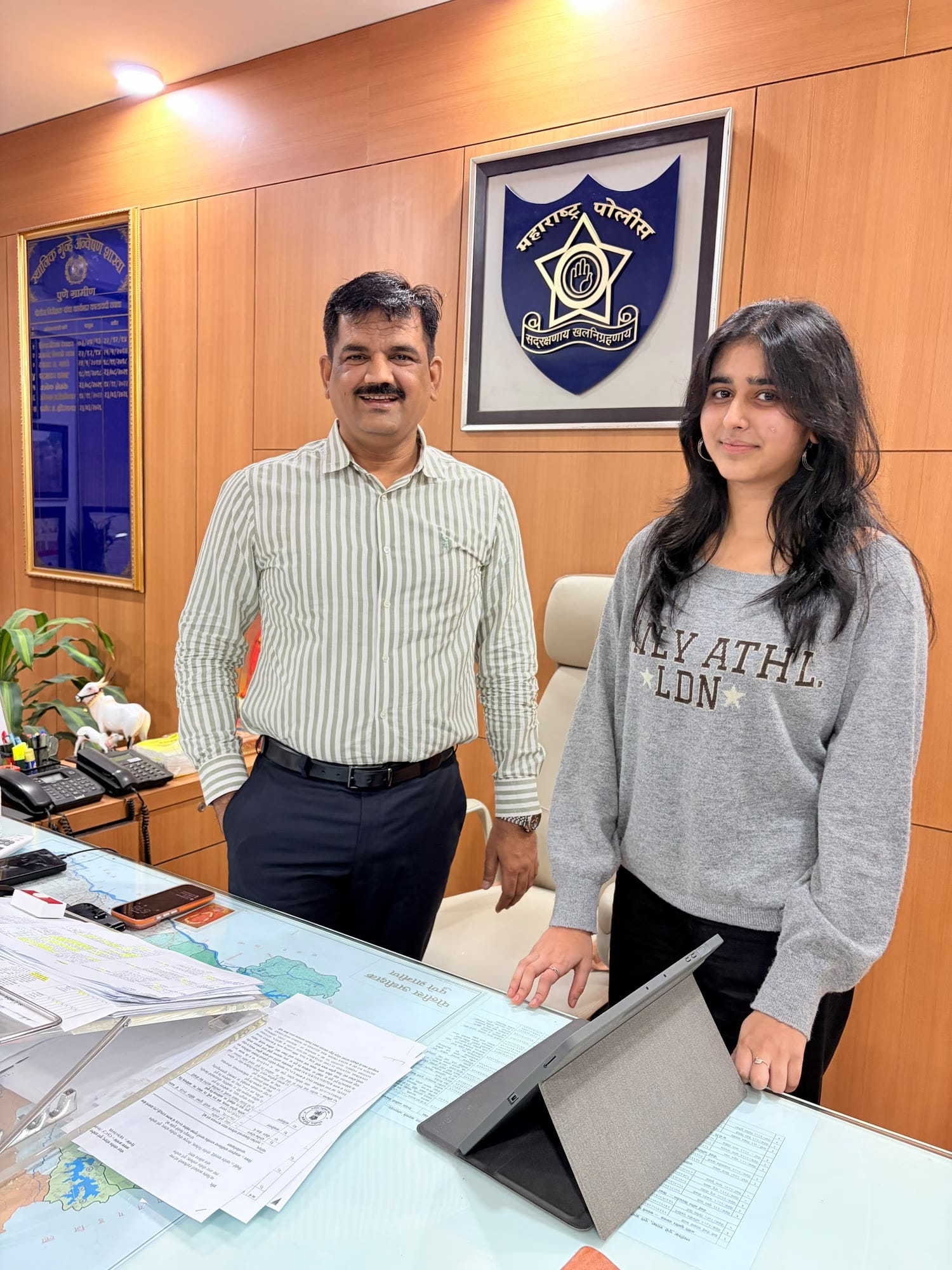 Reeti Maniar of ByteByByte with a police officer at the branch, the police emblem on the wall behind them.